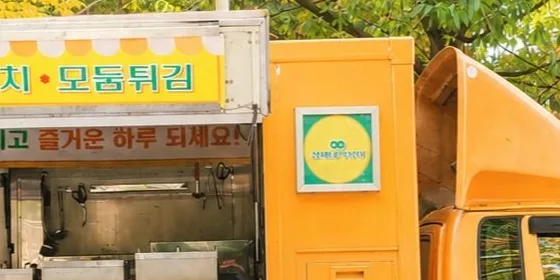 떡볶이·순대·어묵꼬치·모둠튀김 간판을 단 노란 분식 푸드트럭. 드라마 소품으로 꾸몄을 때의 외관